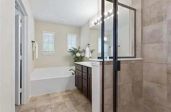 a bathroom with a tub sink and mirror