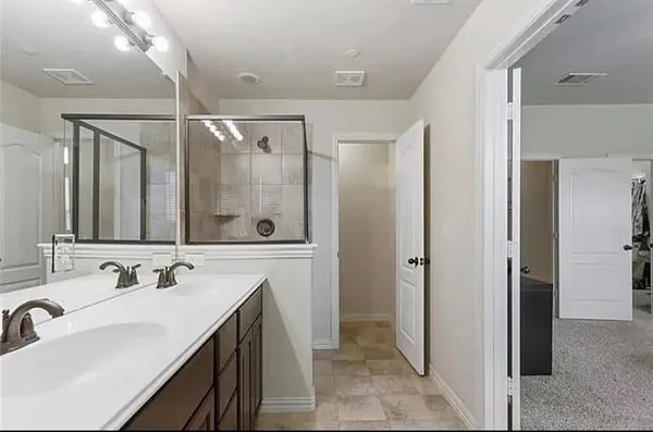 a spacious bathroom with a shower sink and mirror