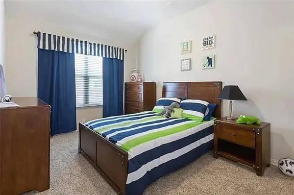 a bed sitting in a bedroom next to a window with lamp