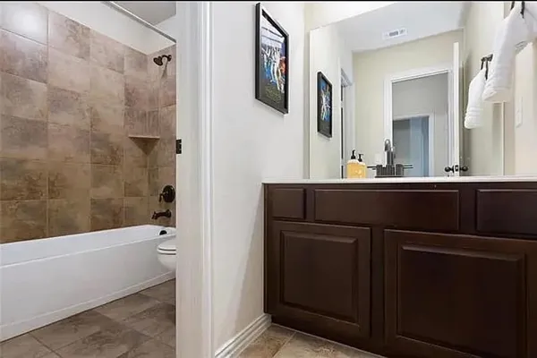 a bathroom with a bathtub sink vanity and mirror