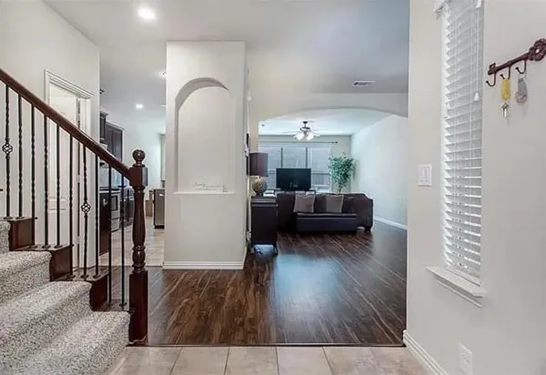 a living room with furniture and a wooden floor