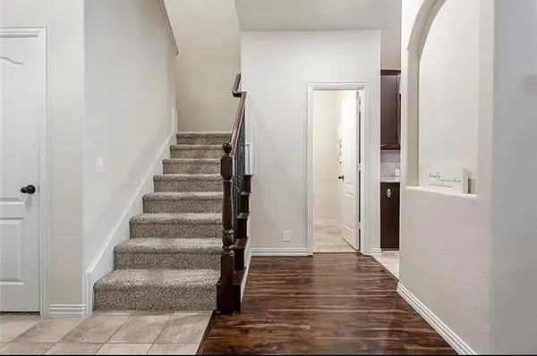 a view of a hallway with wooden floor and entryway