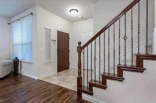 a view of a hallway with wooden floor and staircase
