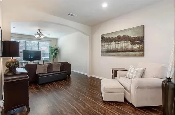 a living room with furniture and wooden floor