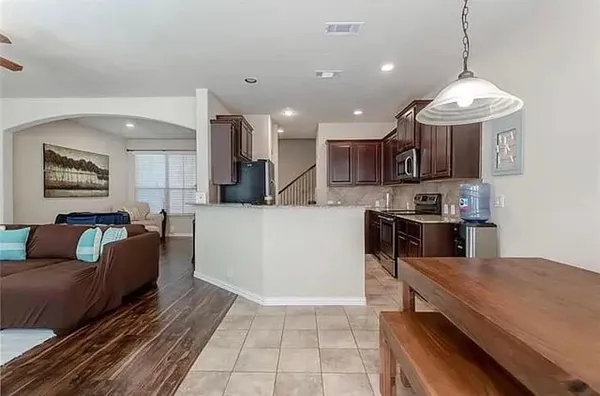 a large kitchen with stainless steel appliances kitchen island granite countertop a stove a sink a microwave and a refrigerator