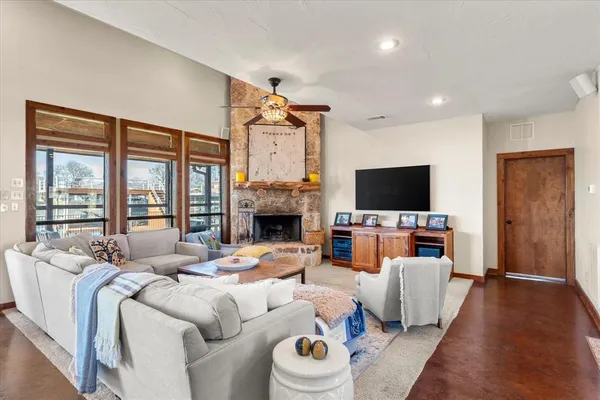 a living room with furniture a flat screen tv and a fireplace