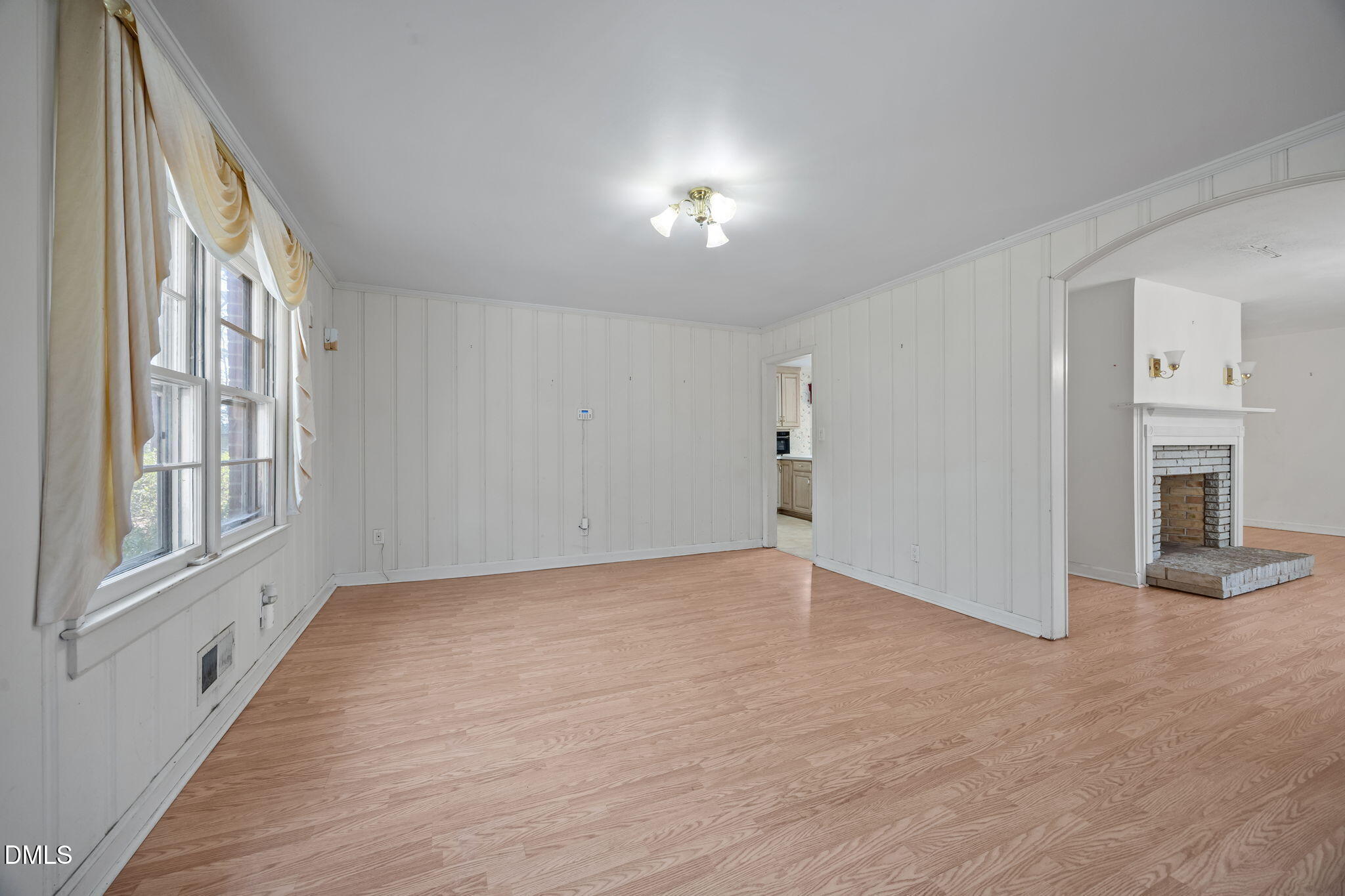 2009 Philcrest Road Raleigh, NC 27612 - Photo 4 of 29 a view of an empty room with wooden floor and a window