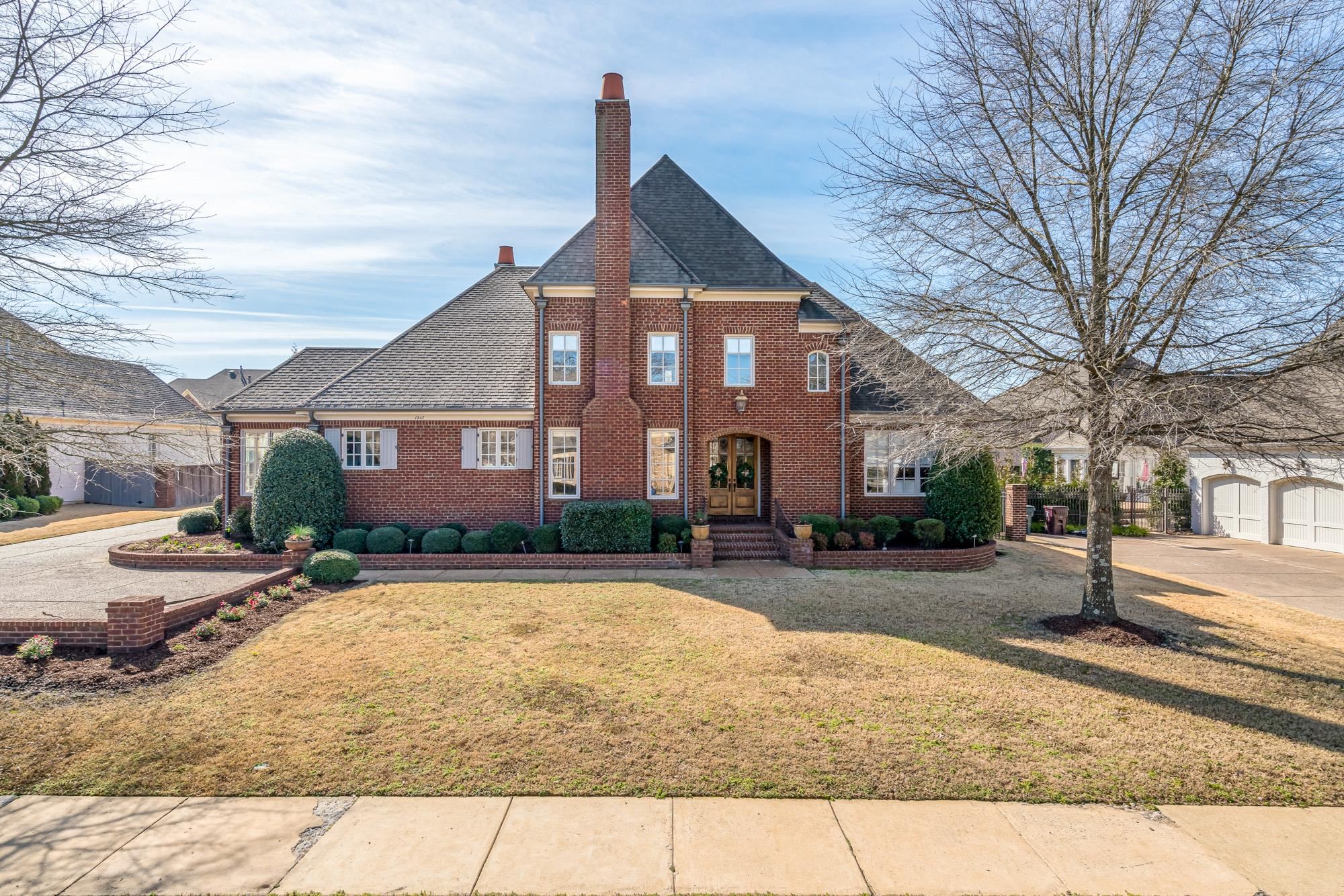 1247 Braywind Drive Collierville, TN 38017 - Photo 1 of 25 a view of a brick house next to a yard with road