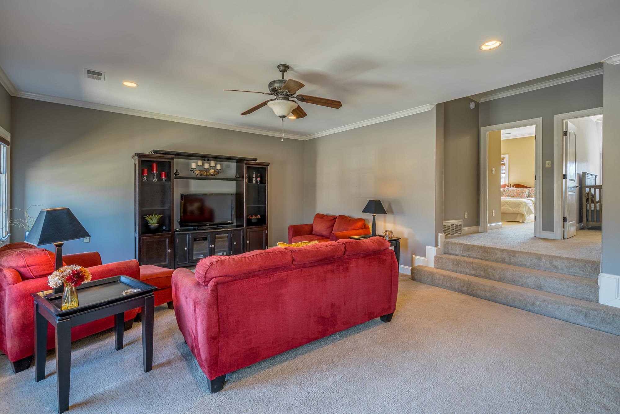 1247 Braywind Drive Collierville, TN 38017 - Photo 18 of 25 a living room with furniture a flat screen tv and a chandelier