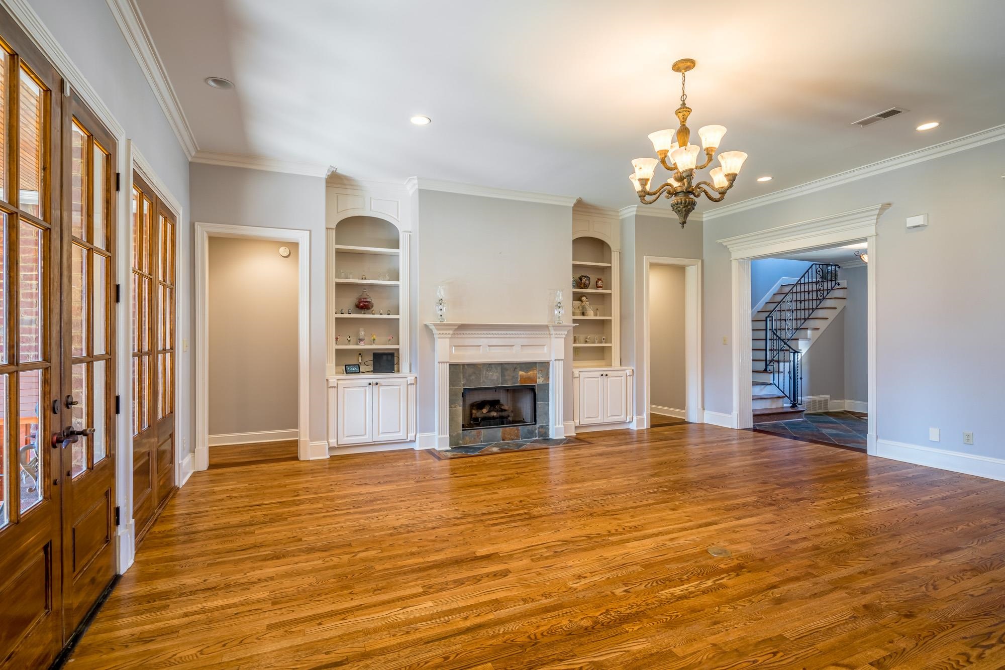1247 Braywind Drive Collierville, TN 38017 - Photo 5 of 25 a view of a livingroom with a fireplace a chandelier and wooden floor