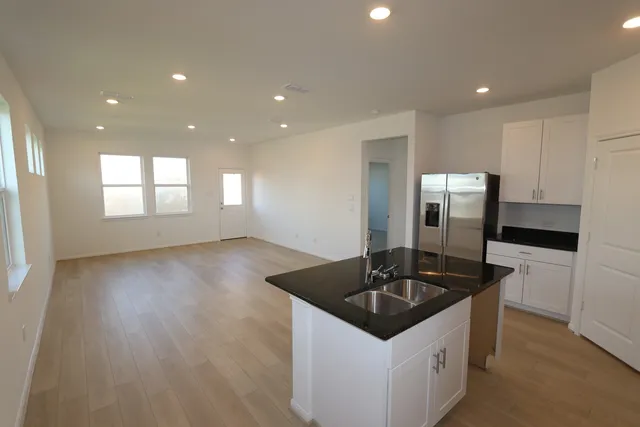 a kitchen with granite countertop a sink and refrigerator