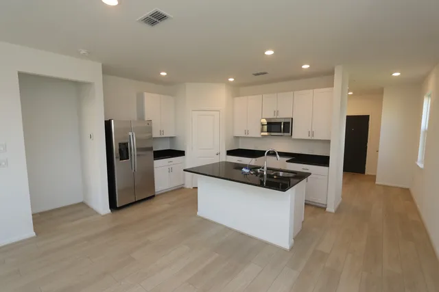 a kitchen with stainless steel appliances granite countertop a stove a refrigerator and a sink