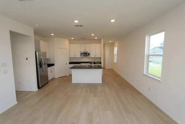 a view of kitchen with refrigerator and window