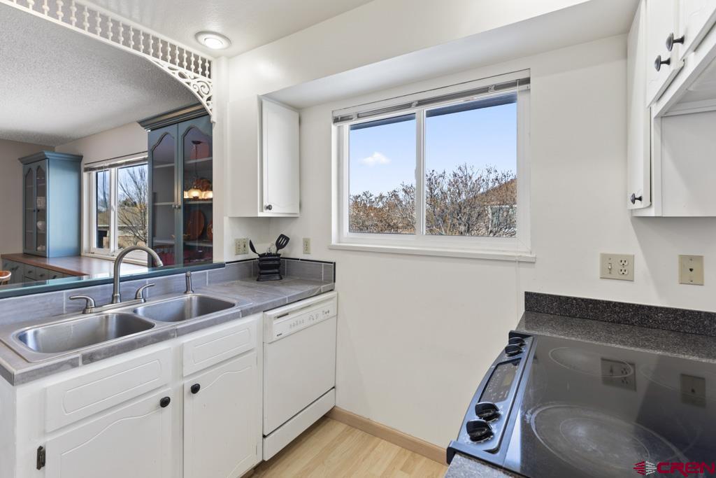 a kitchen with a sink cabinets and wooden floor