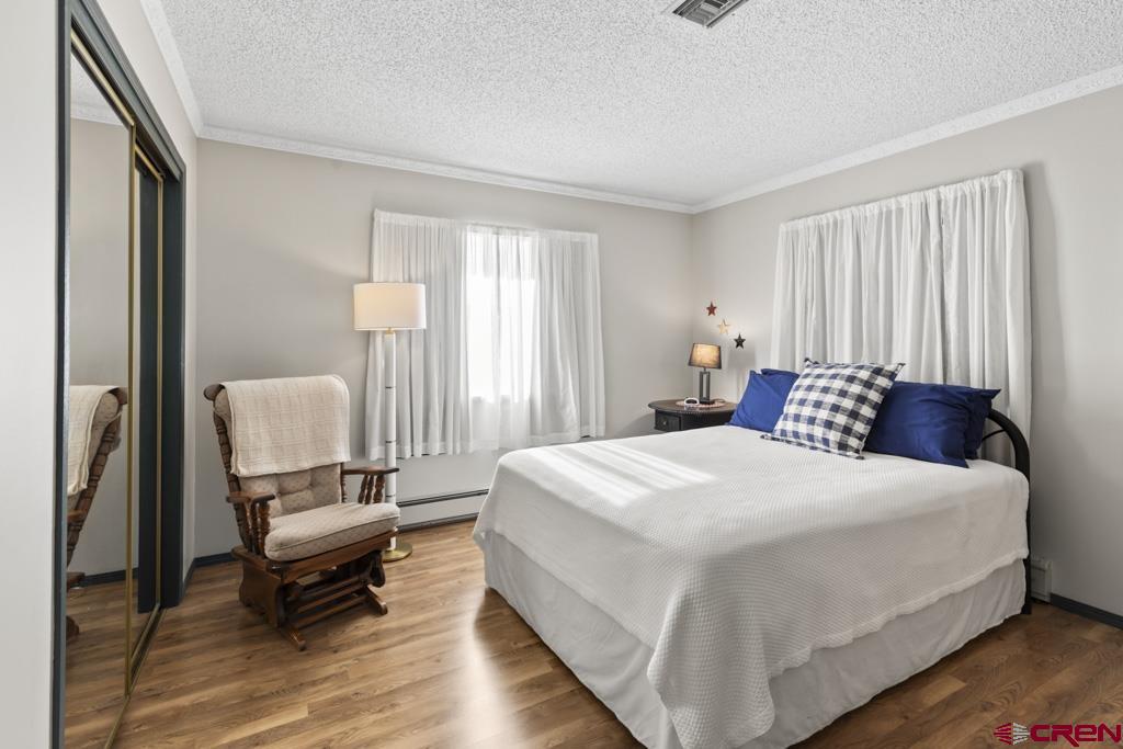 2135 Winston Way, Unit A Montrose, CO 81401 - Photo 11 of 27 a bedroom with a bed and wooden floor