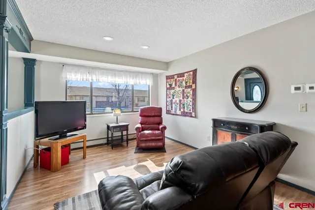a living room with furniture a flat screen tv and a large window