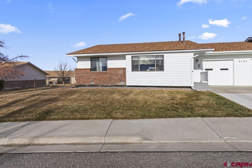 2135 Winston Way, Unit A Montrose, CO 81401 - Photo 16 of 27 a front view of a house with a yard