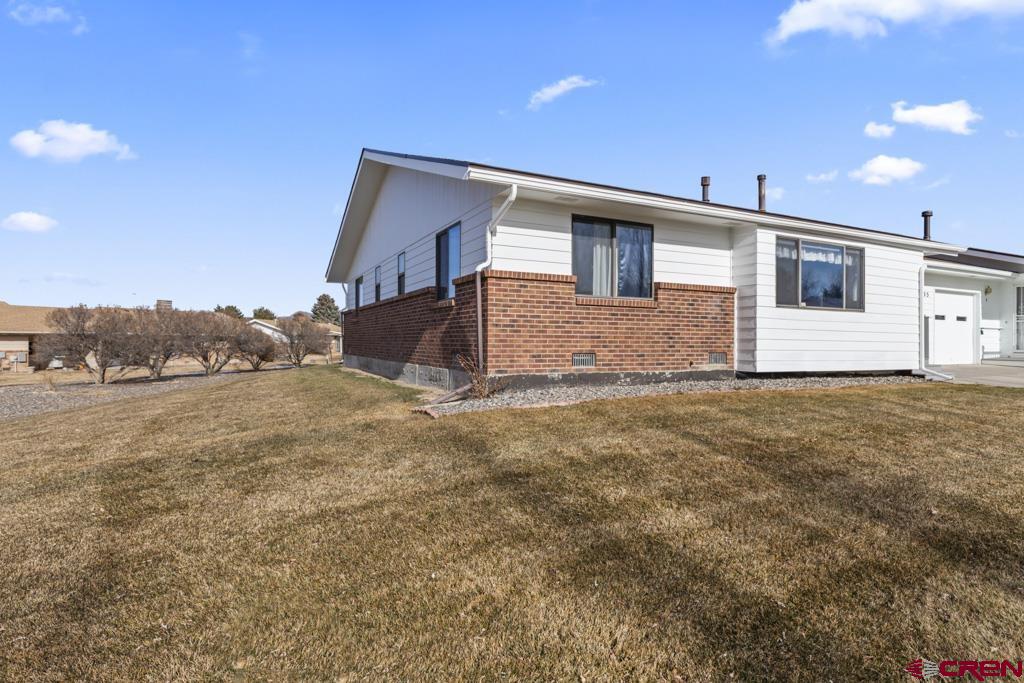 2135 Winston Way, Unit A Montrose, CO 81401 - Photo 17 of 27 a front view of a house with a yard