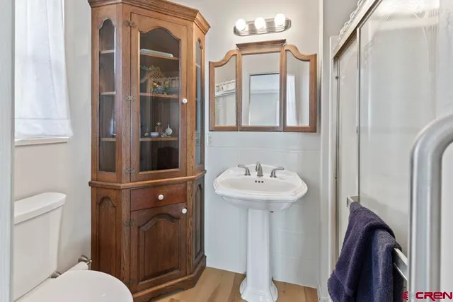 a bathroom with a sink a toilet and shower