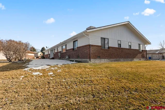 a front view of house with yard covered in snow