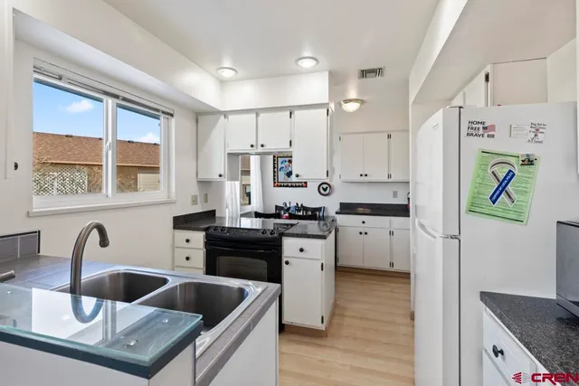 a kitchen with granite countertop a sink stainless steel appliances and cabinets