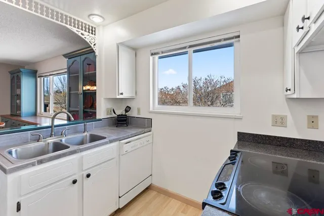 a kitchen with a sink cabinets and wooden floor