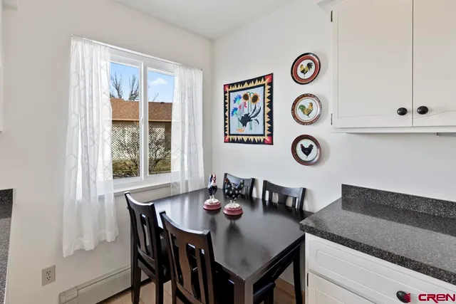 a view of a dining area with furniture and a large window