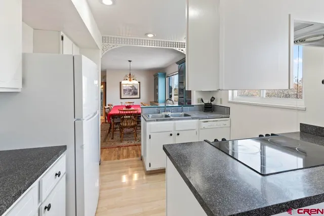 a kitchen with kitchen island granite countertop a sink cabinets and stainless steel appliances