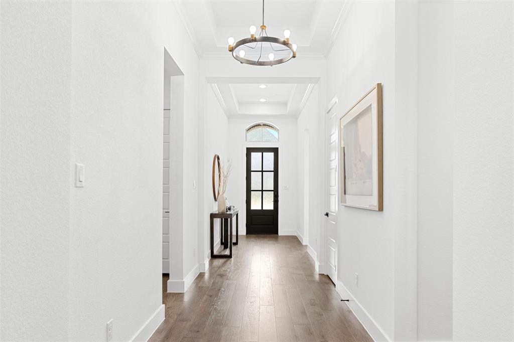 2808 Citation Road Celina, TX 75009 - Photo 3 of 40 a view of a hallway with wooden floor and a chandelier