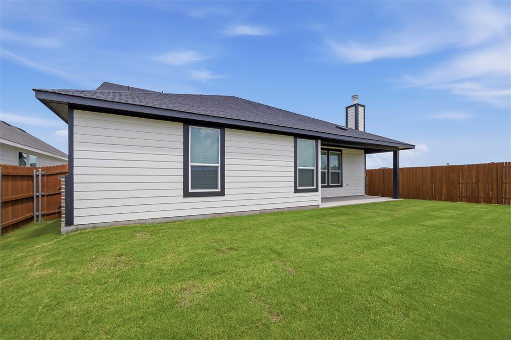 1325 Frio Drive Springtown, TX 76082 - Photo 23 of 24 Spacious backyard featuring a covered patio, dark trim windows, horizontal siding, a substantial chimney, and wood fencing