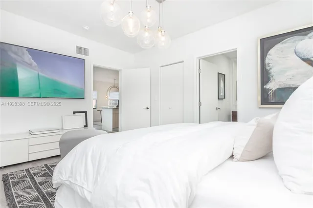 a bedroom with a bed and a chandelier