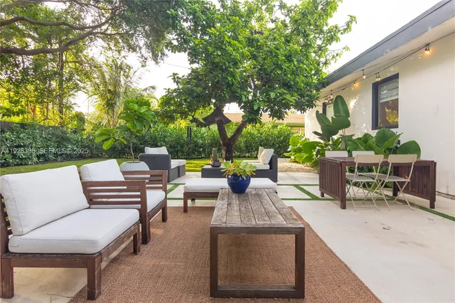 a view of a patio with couches table and chairs and potted plants