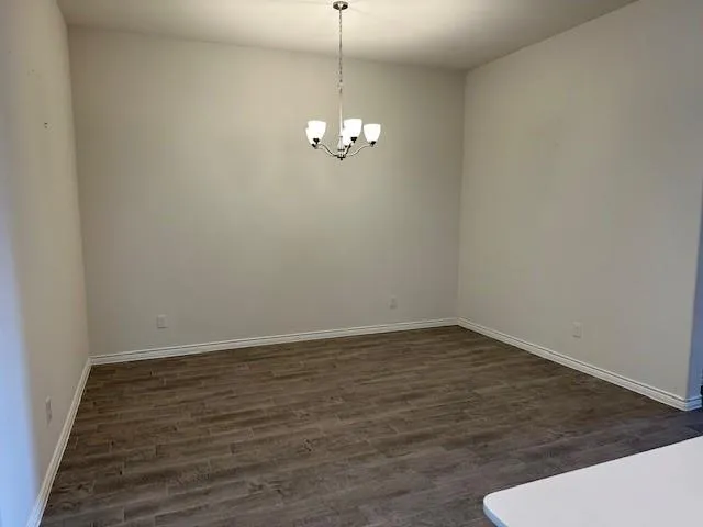 a view of a room with wooden floor and ceiling fan