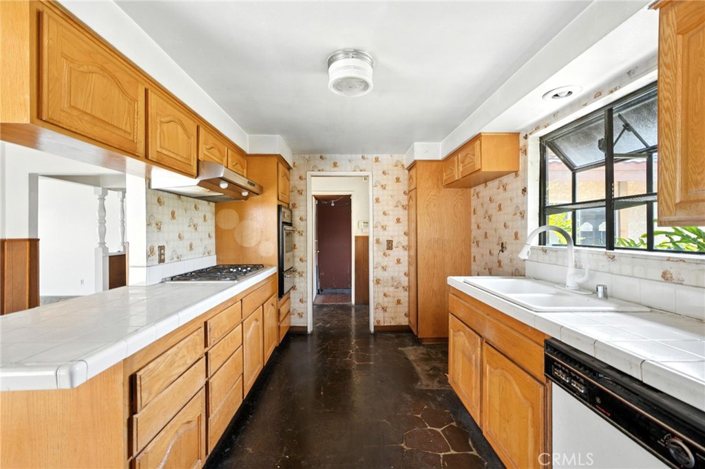 19717 Alonda Drive Carson, CA 90746 - Photo 9 of 31 a large kitchen with stainless steel appliances a sink and a large window