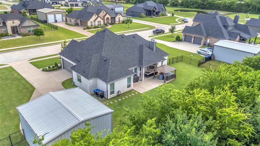 1014 Rennard Street Caddo Mills, TX 75135 - Photo 37 of 39 Expansive backyard featuring a manicured lawn, an extended concrete patio with a hot tub with gazebo, covered outdoor living area with fire place and a large detached metal storage building