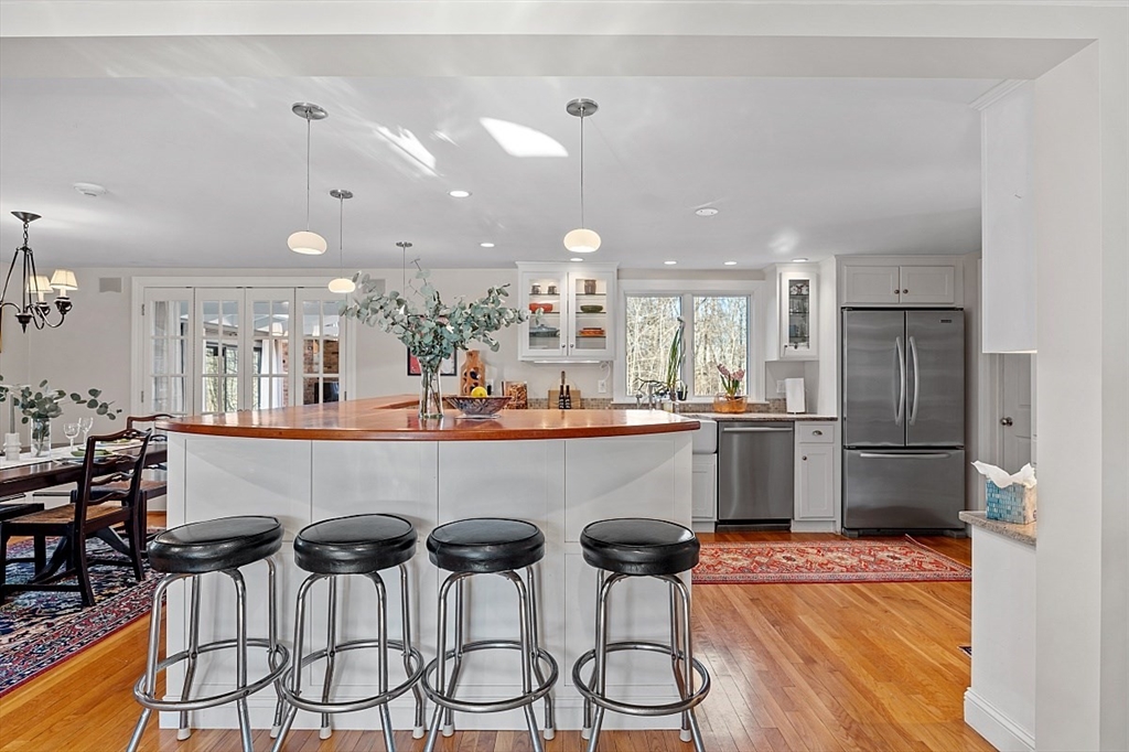8 Honeysuckle Road Hamilton, MA 01982 - Photo 5 of 41 a kitchen with a dining table chairs wooden floor and appliances