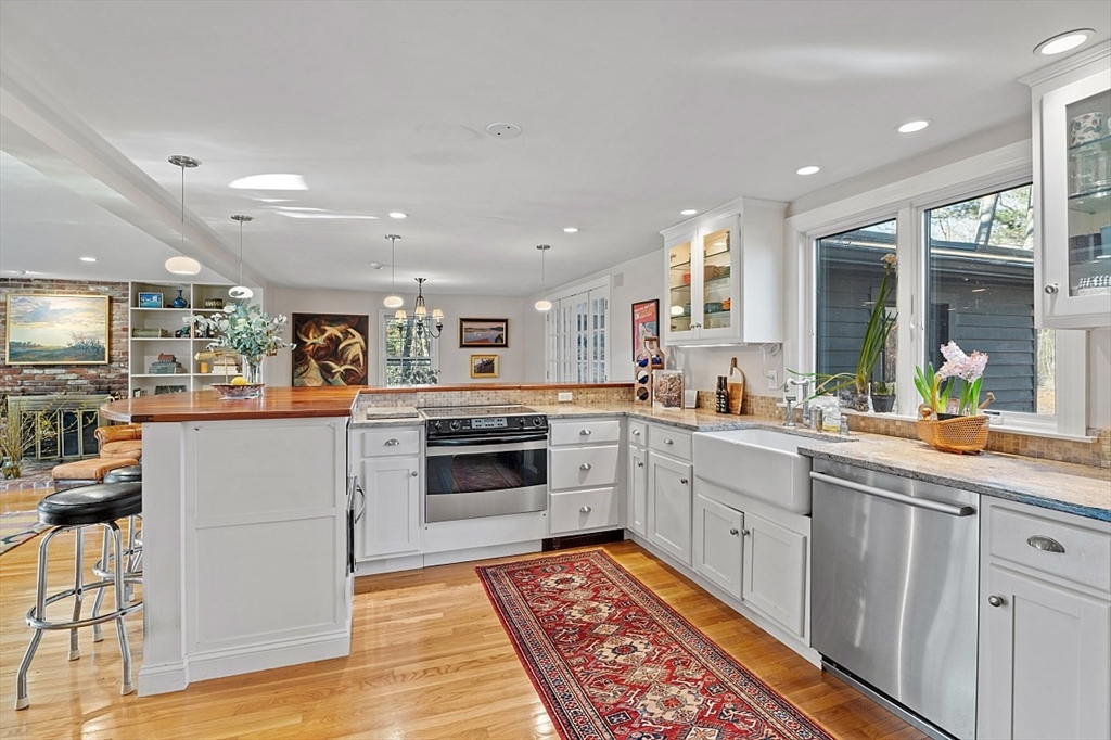8 Honeysuckle Road Hamilton, MA 01982 - Photo 6 of 41 a large white kitchen with stainless steel appliances granite countertop a stove and a sink