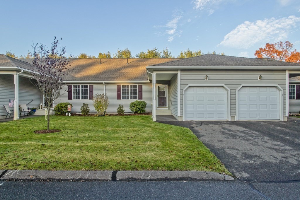 a front view of a house with a yard and potted plants