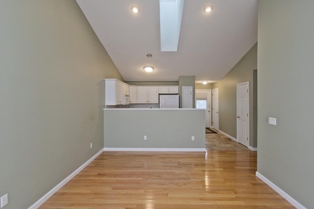 210 Johnson Road, Unit 5 Chicopee, MA 01022 - Photo 3 of 19 a view of a kitchen with an empty room and wooden floor