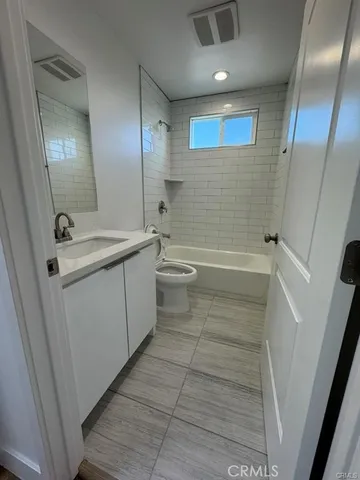 a bathroom with a sink a toilet a mirror and shower