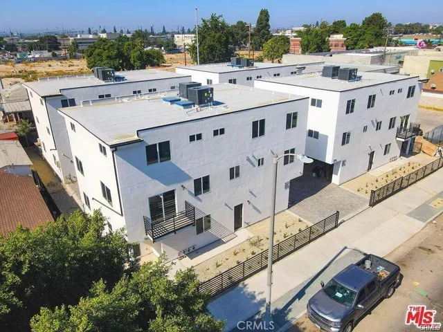 an aerial view of residential houses with outdoor space and parking