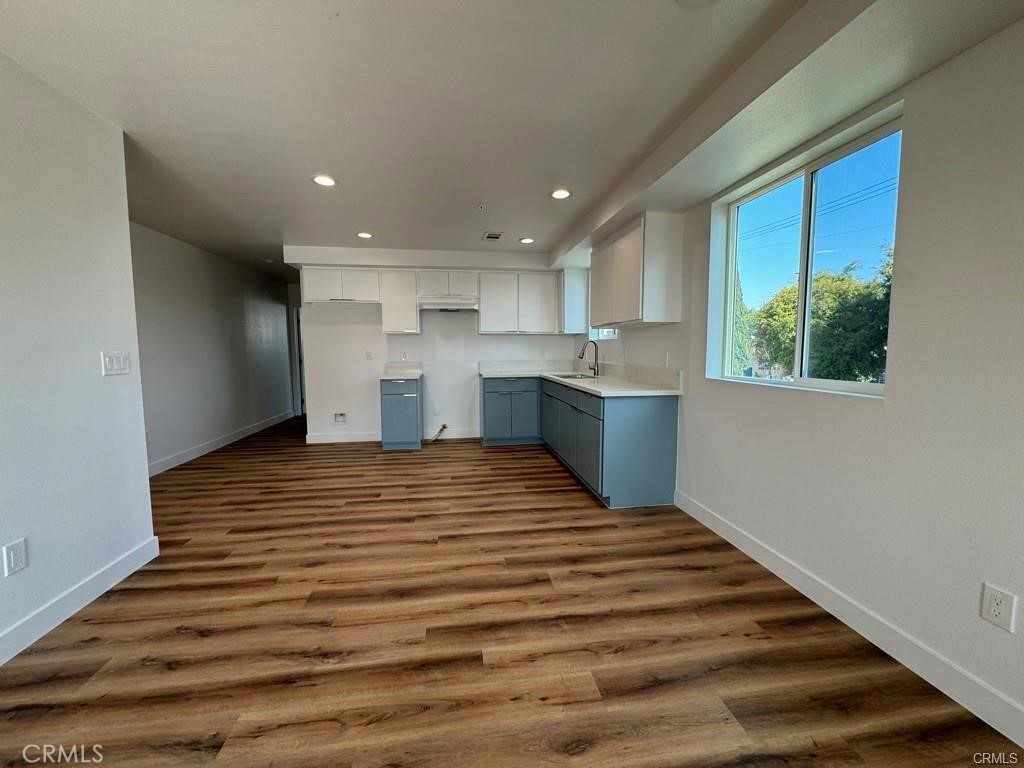 5875 San Pedro Street Los Angeles, CA 90003 - Photo 4 of 17 a big room with wooden floor and kitchen view