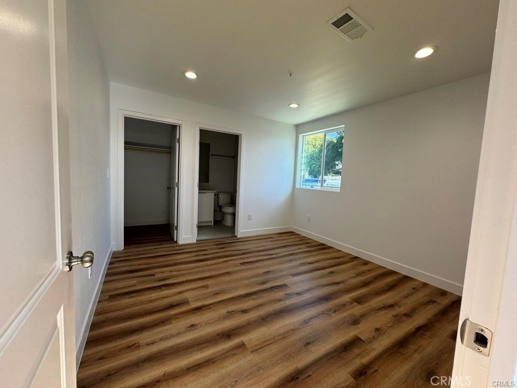 5875 San Pedro Street Los Angeles, CA 90003 - Photo 8 of 17 an empty room with wooden floor and windows