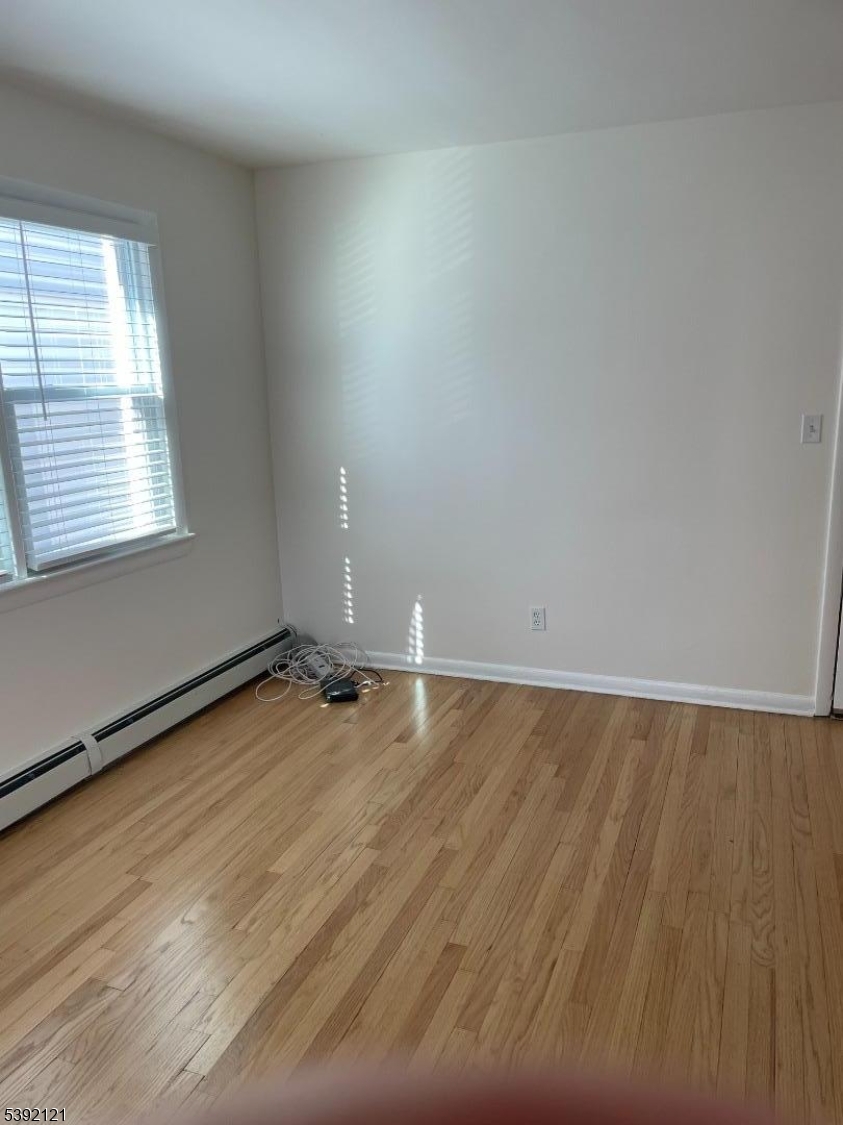 5 Mt Vernon Avenue, Unit 2 Bloomfield, NJ 07003 - Photo 4 of 8 an empty room with wooden floor and windows