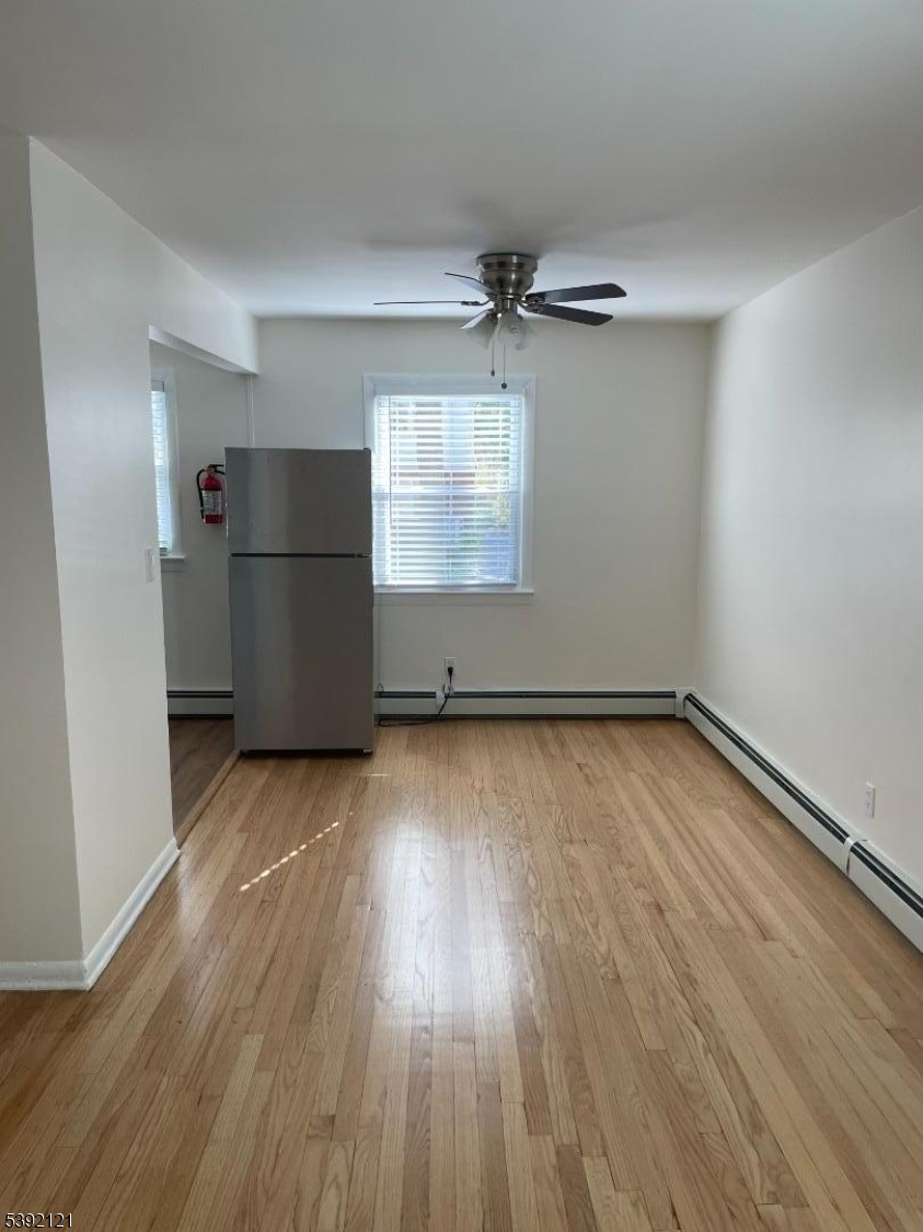 5 Mt Vernon Avenue, Unit 2 Bloomfield, NJ 07003 - Photo 5 of 8 an empty room with wooden floor and windows