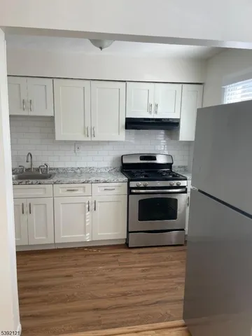 a kitchen with granite countertop white cabinets and stainless steel appliances