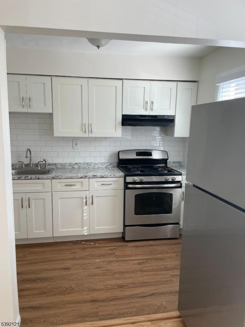 5 Mt Vernon Avenue, Unit 2 Bloomfield, NJ 07003 - Photo 6 of 8 a kitchen with granite countertop white cabinets and stainless steel appliances