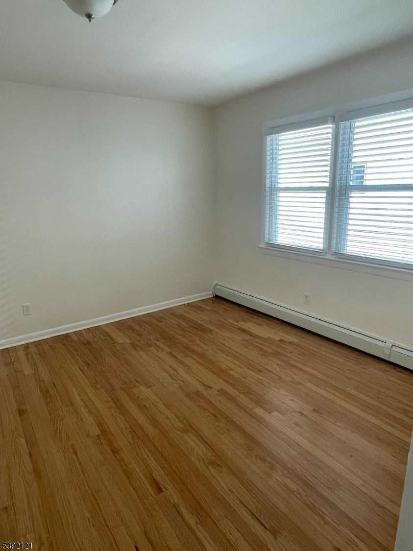 5 Mt Vernon Avenue, Unit 2 Bloomfield, NJ 07003 - Photo 8 of 8 wooden floor in an empty room with a window