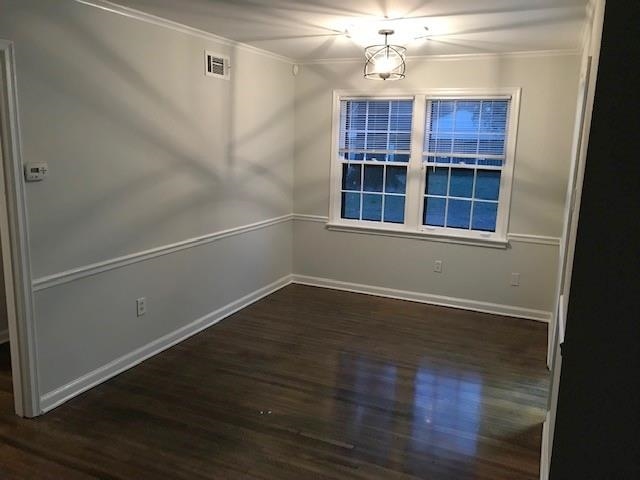 1633 Ivy Road Memphis, TN 38117 - Photo 4 of 14 an empty room with wooden floor cabinet and windows