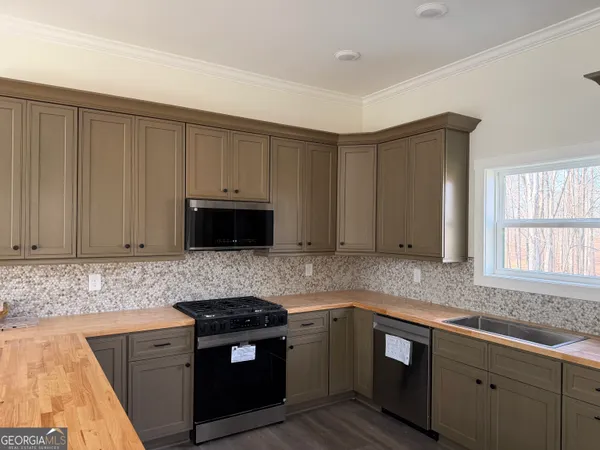 a kitchen with granite countertop cabinets stainless steel appliances and a counter space